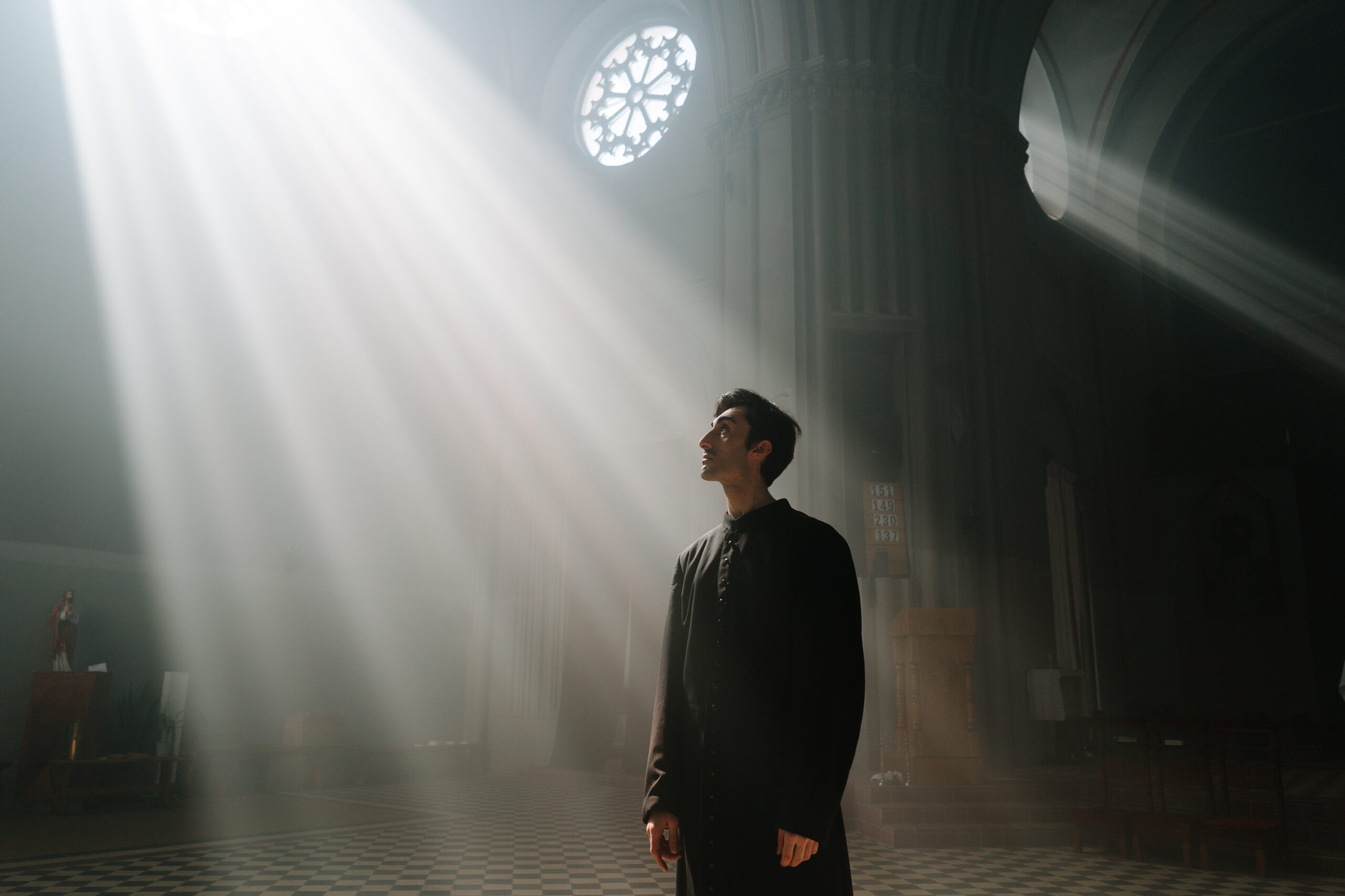 A man engulfed in a ray of bright light floading from the ceiling of a church building