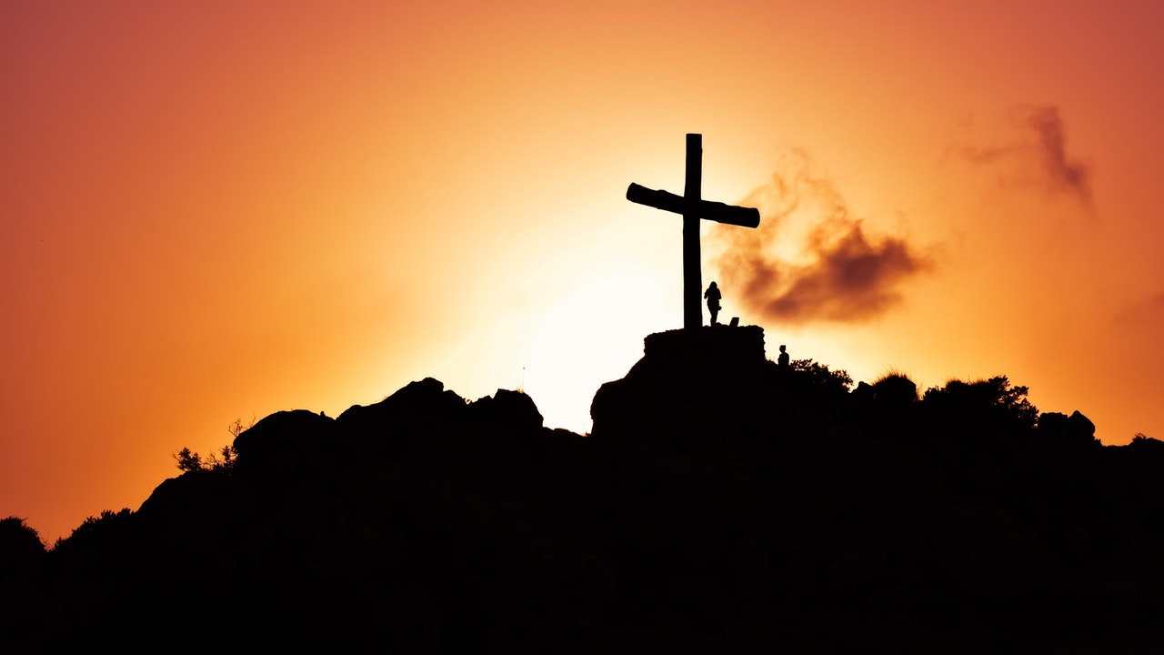 A silhouet of the Cross of Jesus against red fiery light