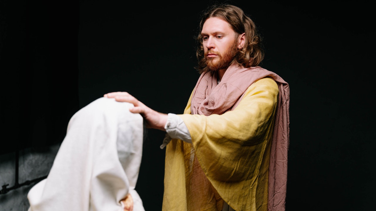 Picture of a man representing Jesus, receiving and parying for a woman kneeling before Him.