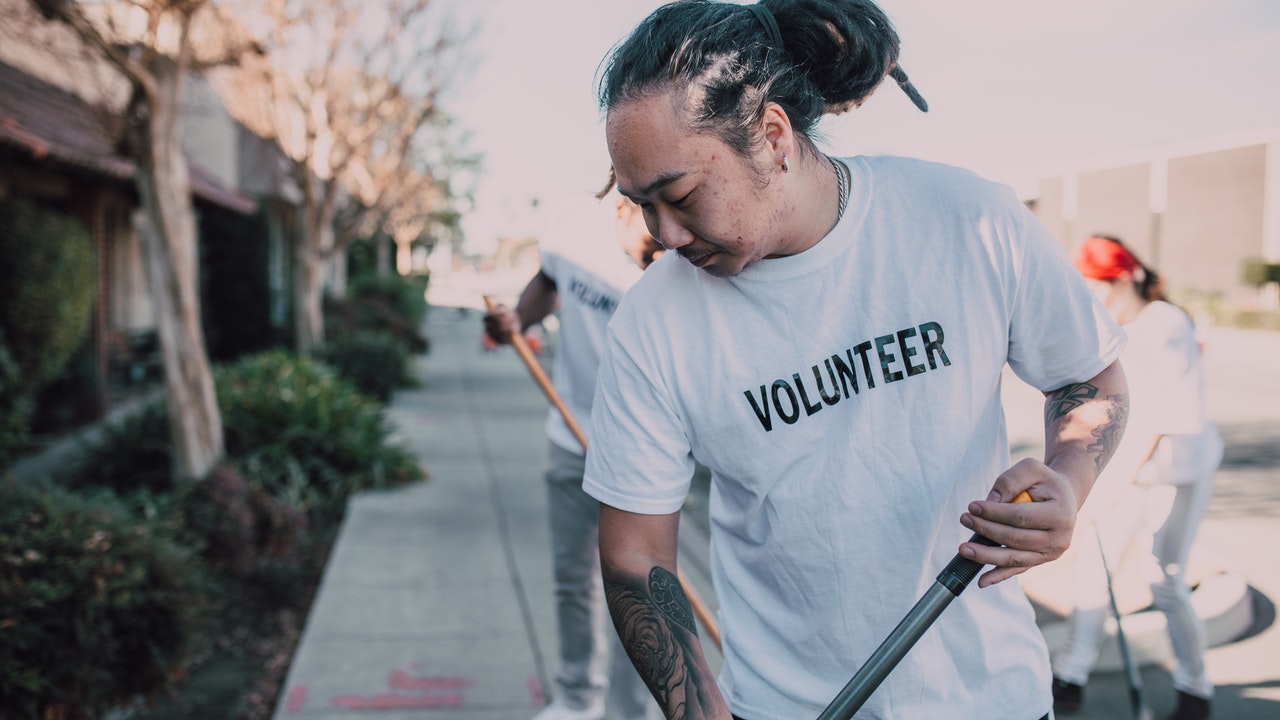 Volunteers sweeping the streets, demonstarting generosity.